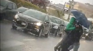 Ragazzi sotto la pioggia battente,  agente di polizia commuove il web
