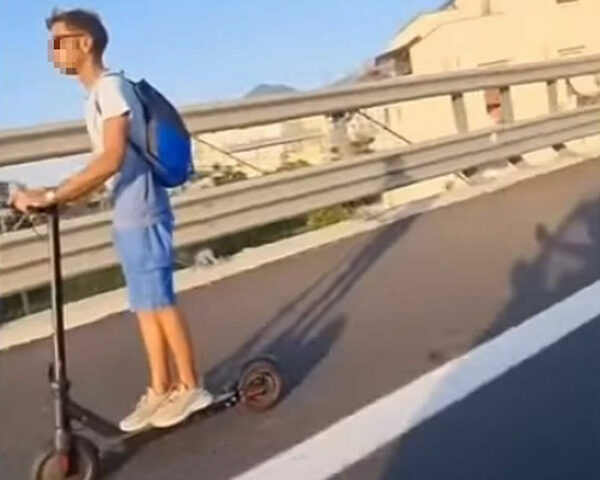 Giovane con il monopattino in autostrada